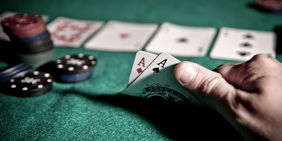 德州撲克玩家手持AA底牌與籌碼｜Texas Hold’em Poker強牌策略